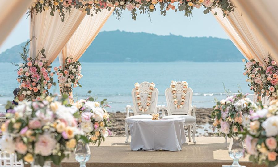 A beautiful beach ceremony decorated with flowers, showcasing an exquisite Indian wedding package setting.